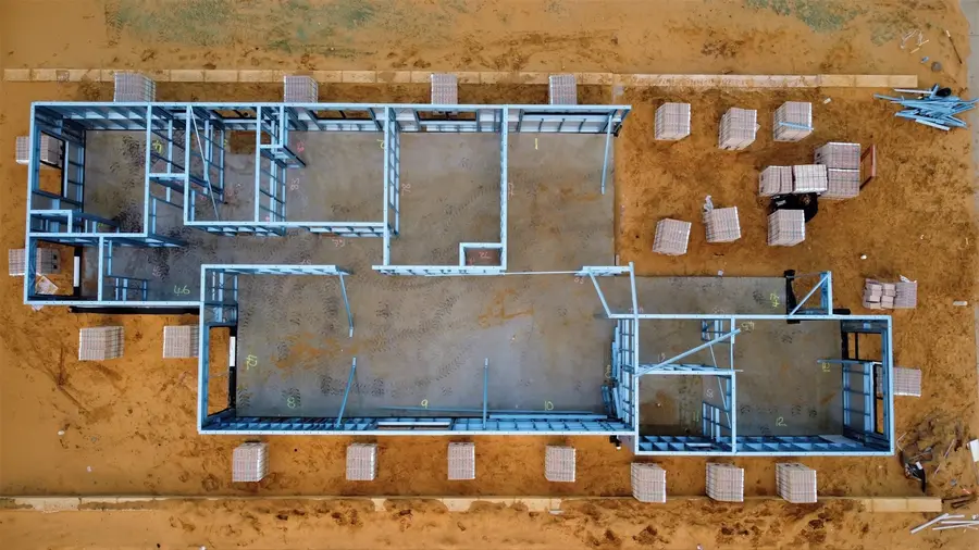 Luftbild einer Baustelle: Fundament mit Bewehrung und Schalung im ausgehobenen Boden