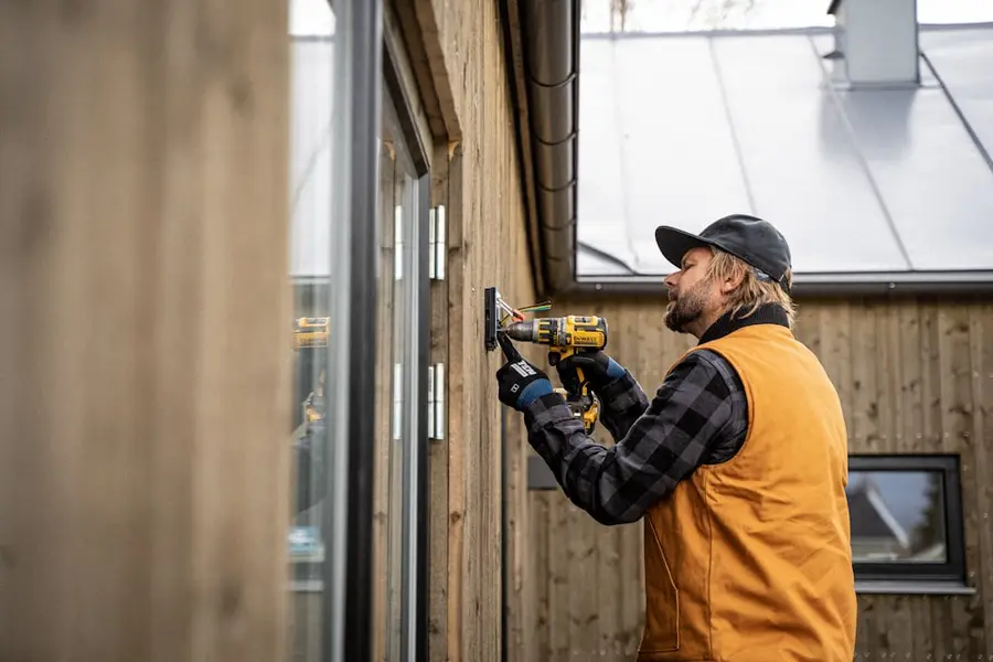 Handwerker schraubt mit dem Akkuschrauber an einem Fensterrahmen