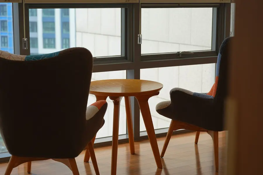 Zwei Sessel an einem runden Tisch vor dem Fenster