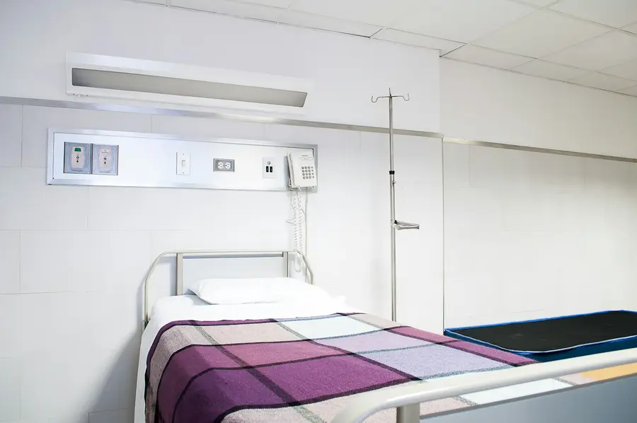 Frisch bezogenes Pflegebett in einem hellen Behandlungszimmer