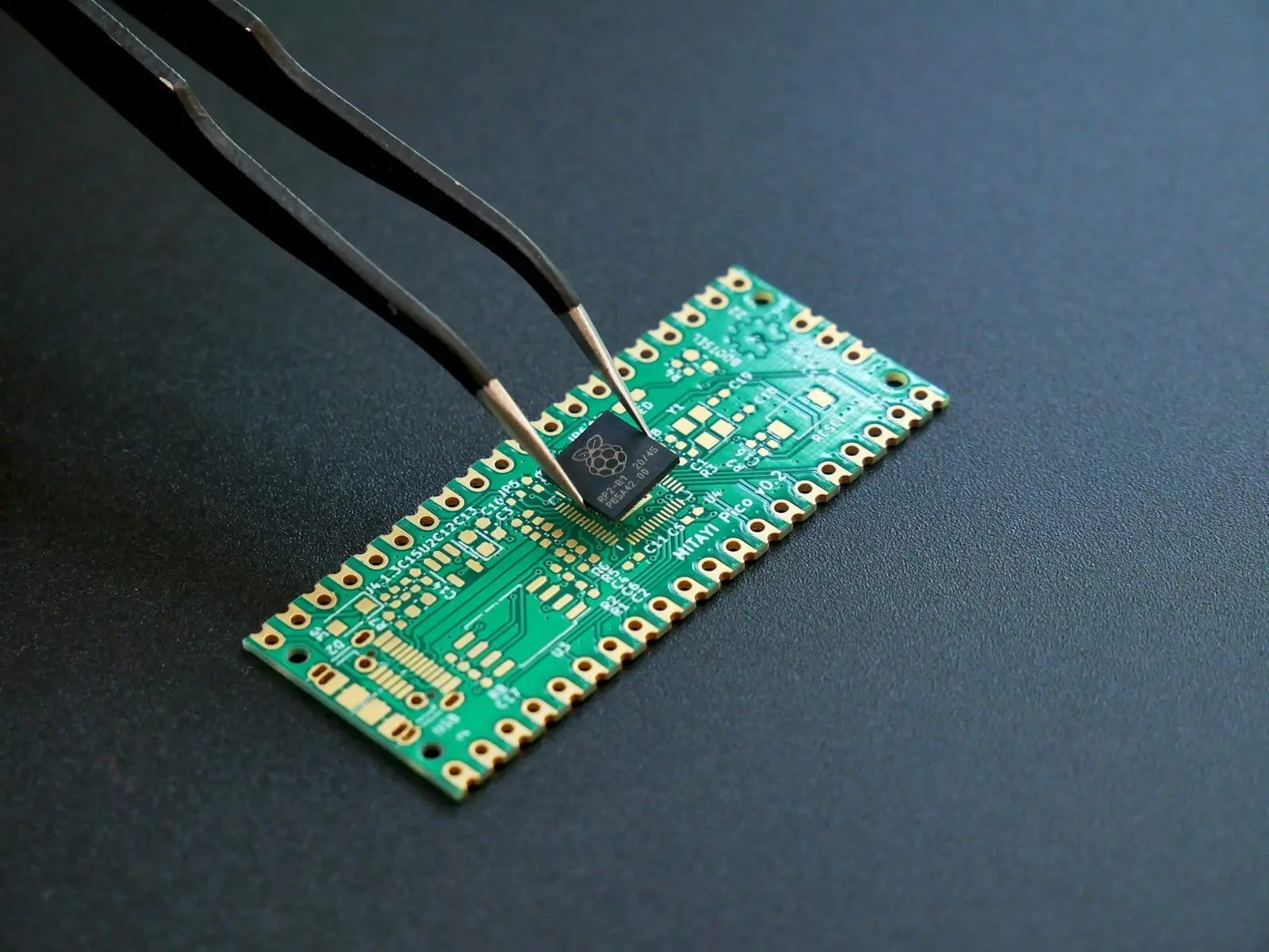 Pinzette setzt einen Chip auf eine grüne Platine