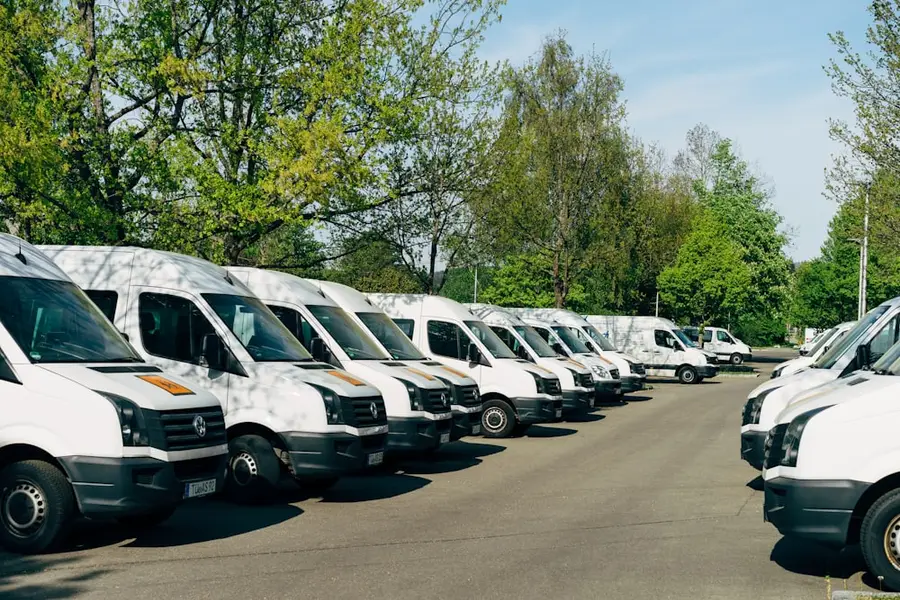 Reihe weißer Transporter auf einem Firmenhof