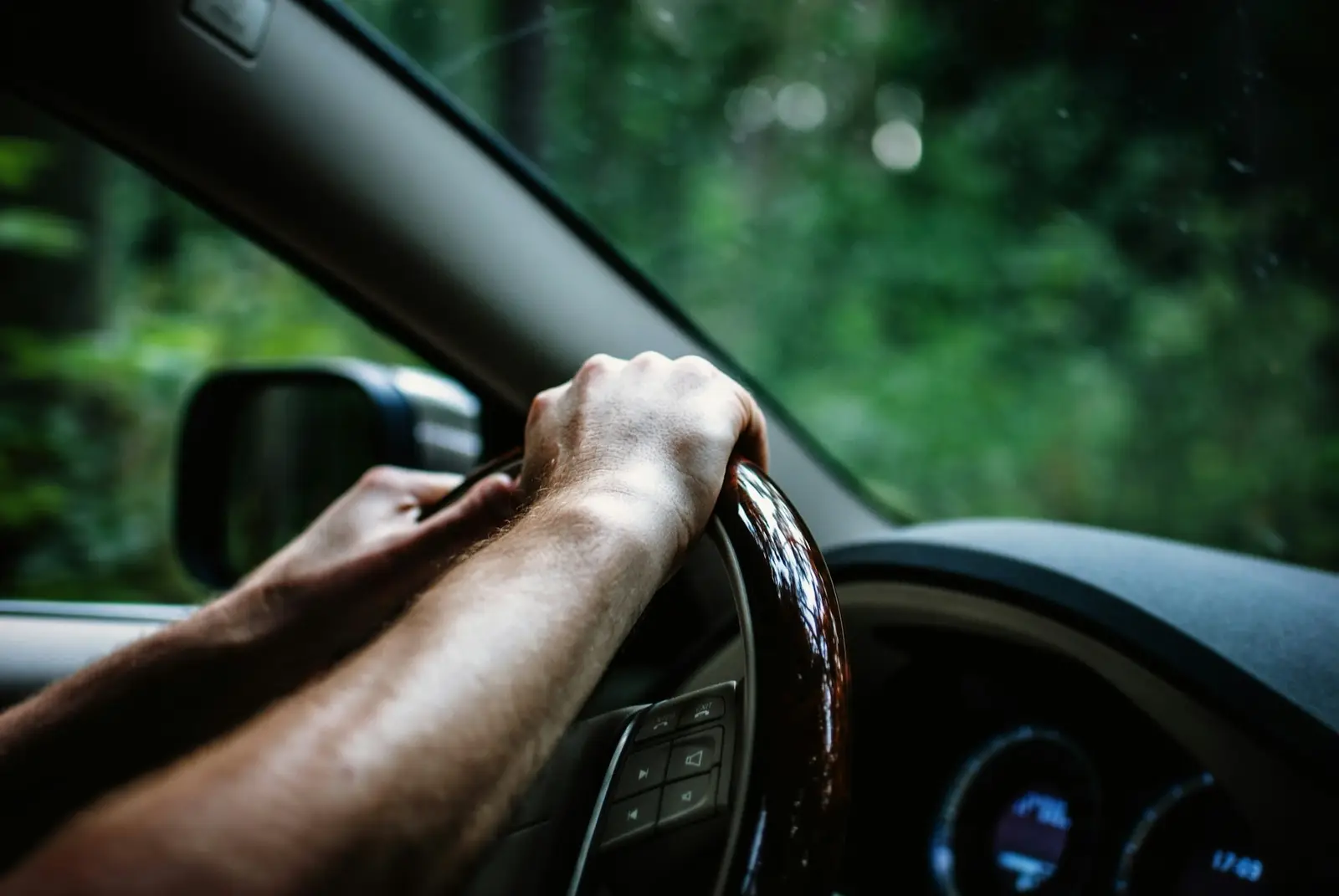 Hände halten das Lenkrad eines Autos