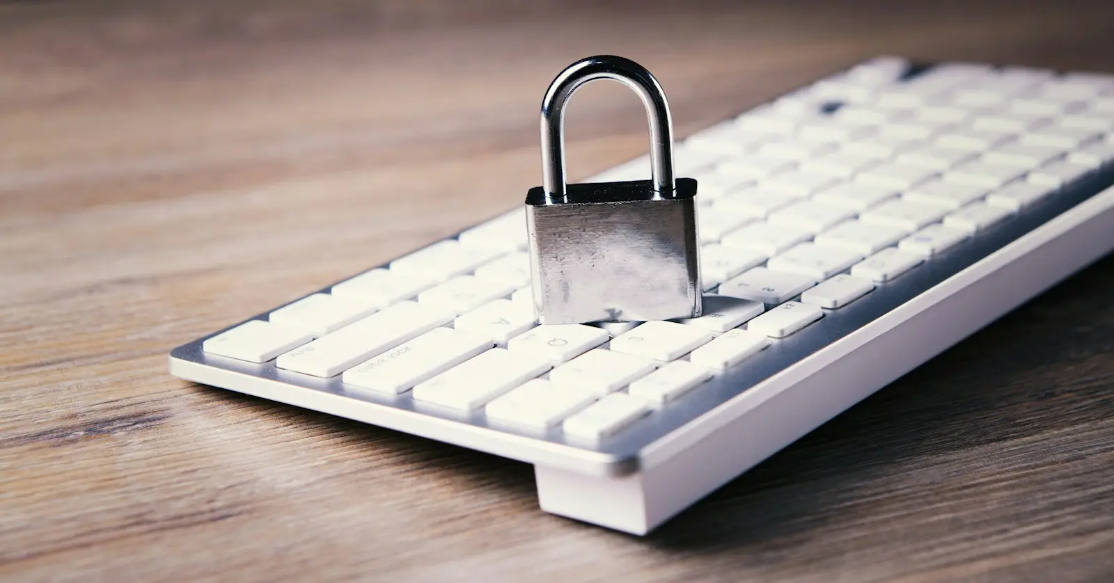 Ein geschlossenes Vorhängeschloss steht auf einer weißen Computertastatur