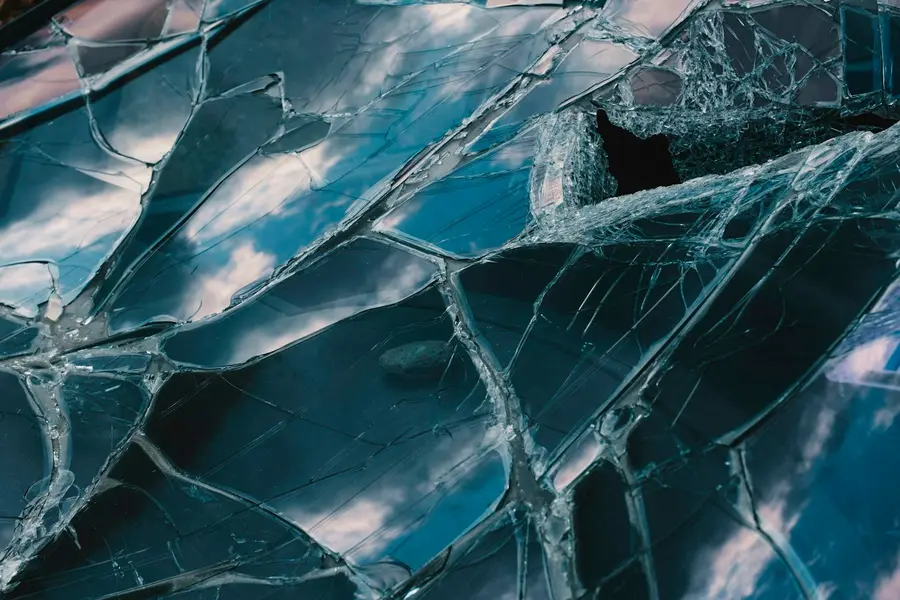 Zersplitterte Glasscheibe, auf der ein Stein liegt