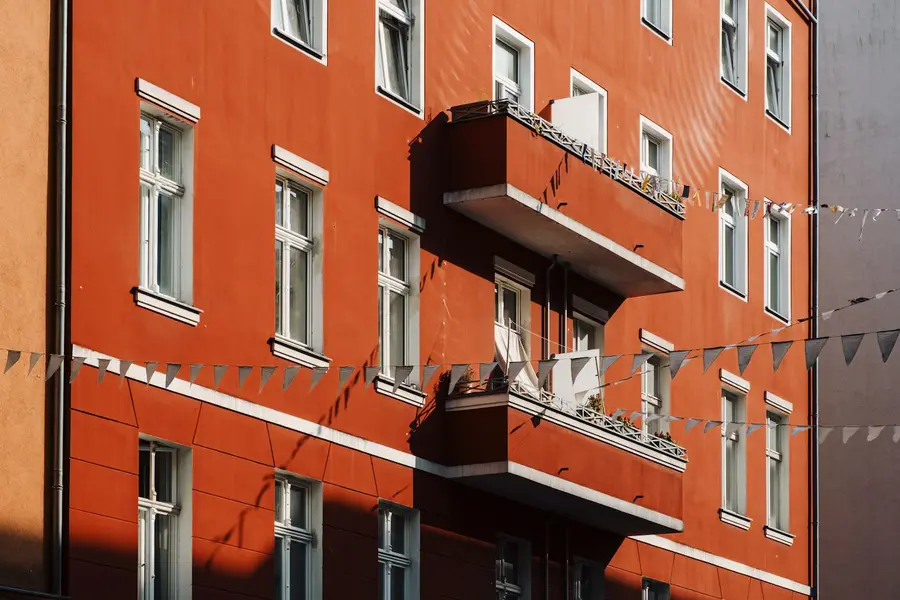Rote Altbaufassade mit Balkonen und Wimpelkette