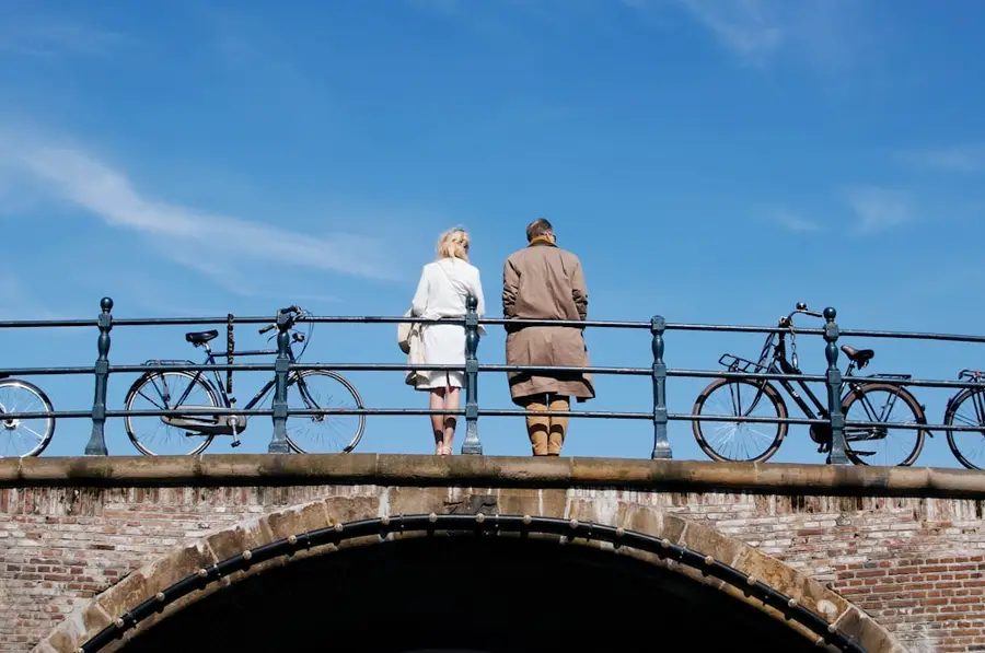 Älteres Paar steht mit seinen Fahrrädern auf einer Brücke