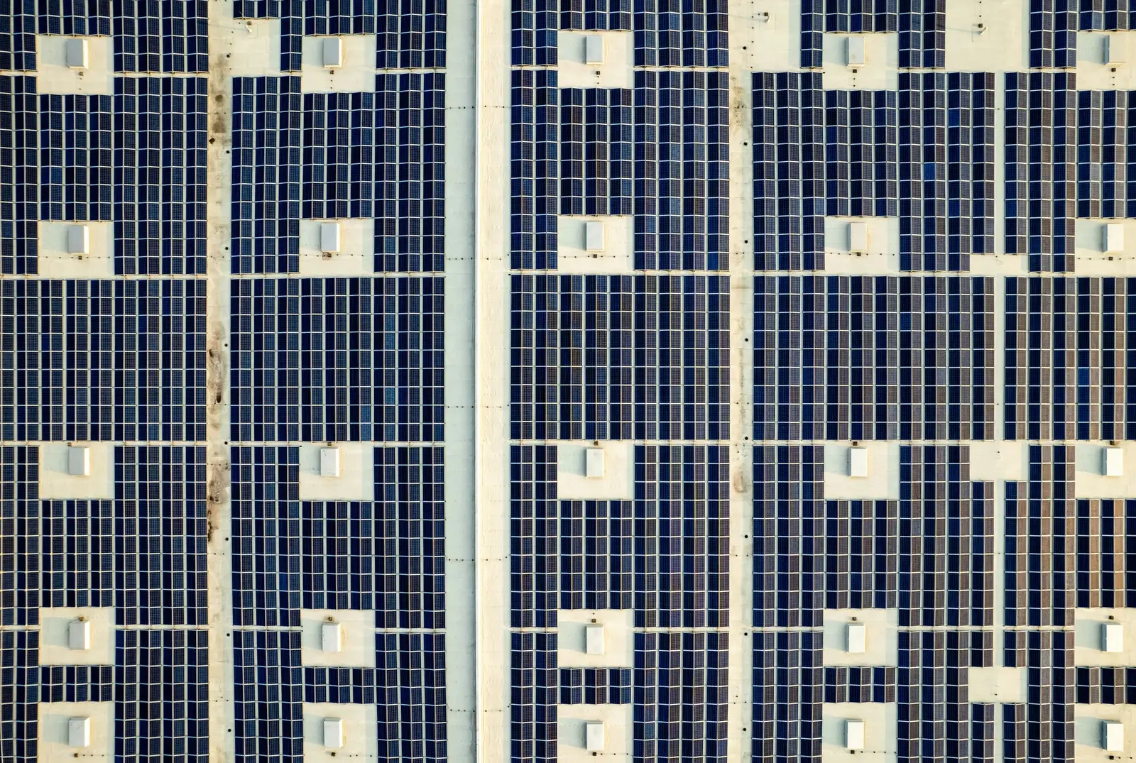 Dachfläche mit regelmäßig angeordneten Solarmodulen aus der Luft