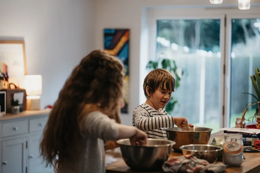 Zwei Kinder rühren in Schüsseln auf der Küchenarbeitsplatte