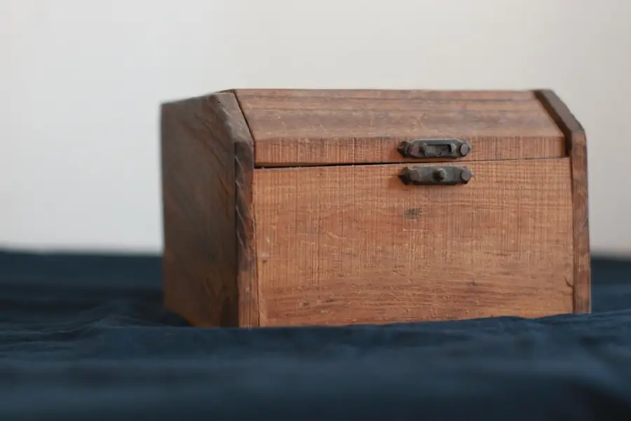 Verschlossene Holztruhe mit Metallbeschlägen auf einem Tuch