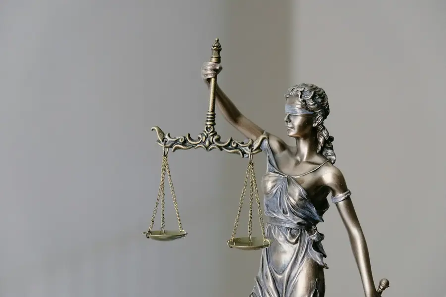 Justitia-Figur mit verbundenen Augen hält eine Waage