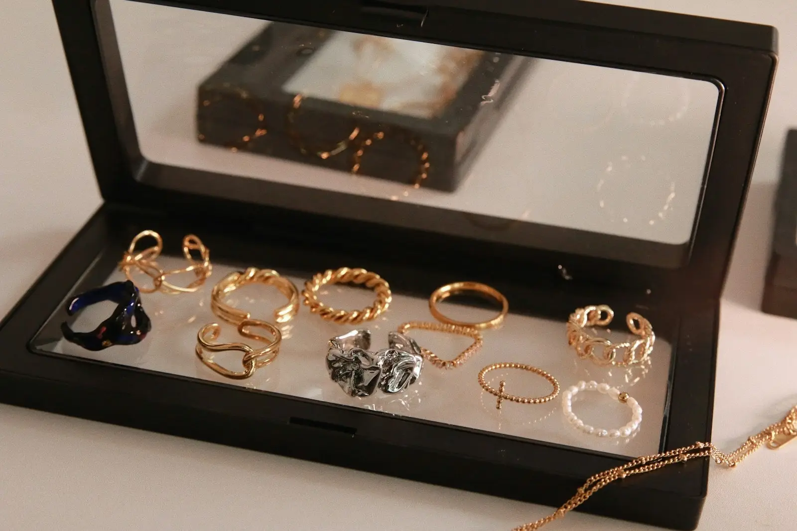 Geöffneter Schmuckkasten mit Ringen, Ketten und weiteren Schmuckstücken