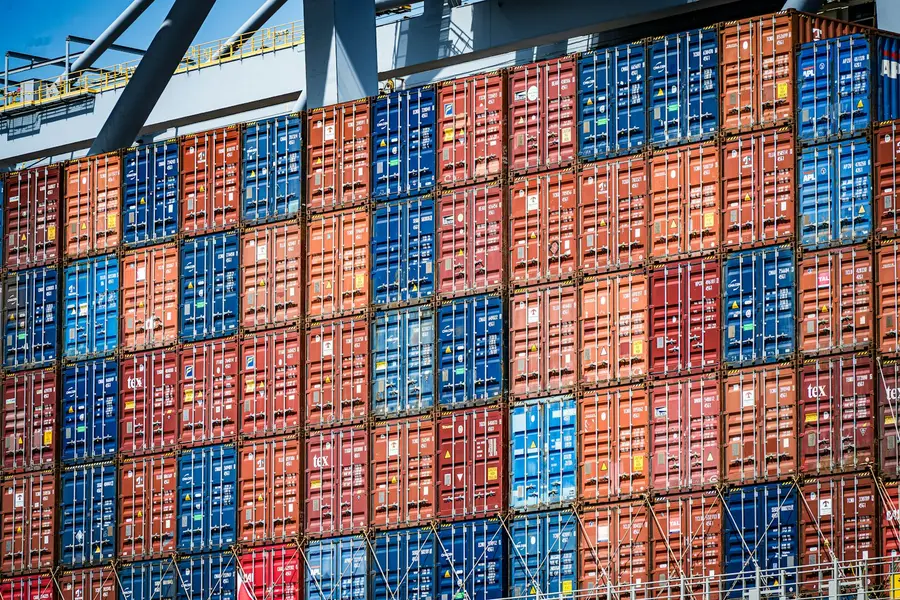 Hoch gestapelte Seecontainer unter einer Verladebrücke