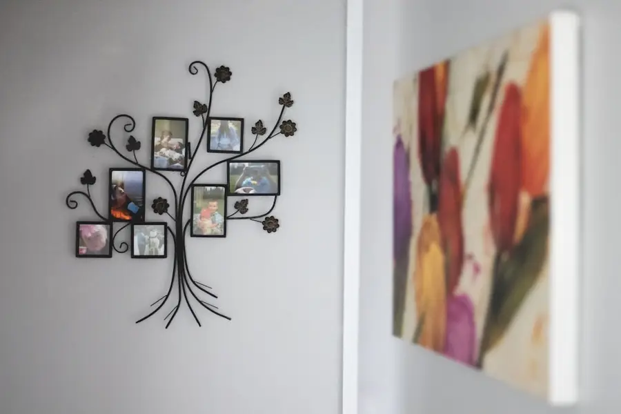 Bilderrahmen in Form eines Baums mit Familienfotos an einer Wohnzimmerwand